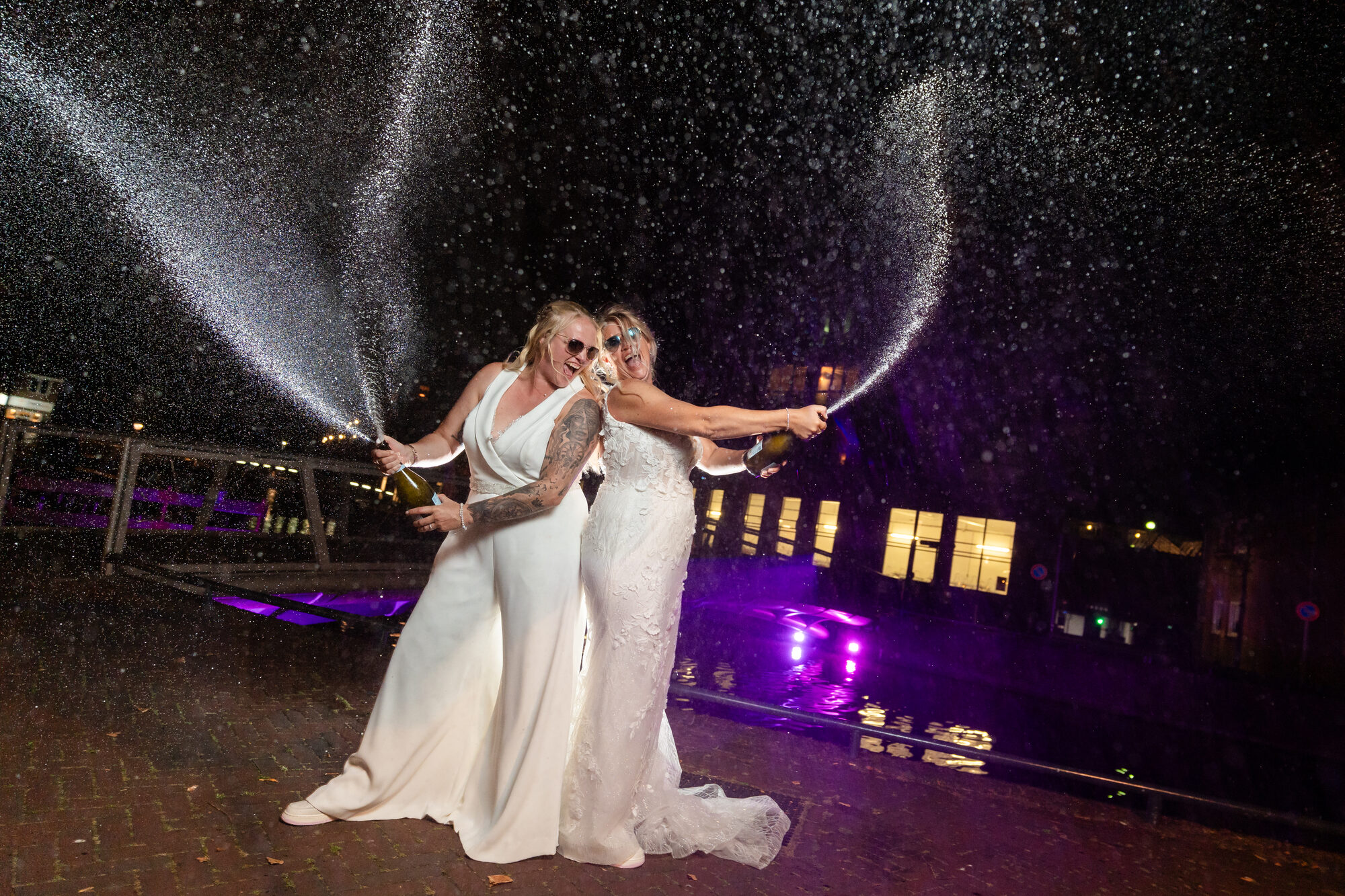 Bruidspaar spuit champagne tijdens het feest bij De Jongens Van