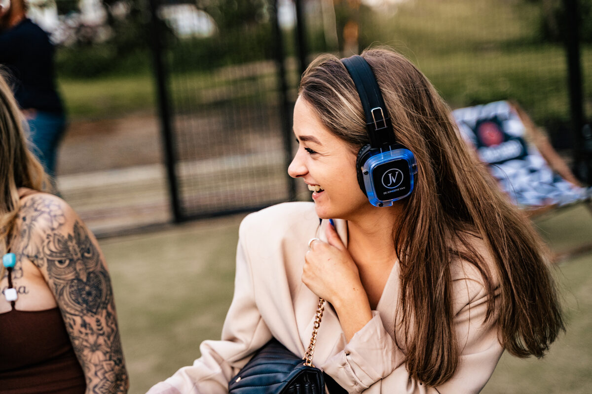 Gast met blauw oplichtende silent disco koptelefoon